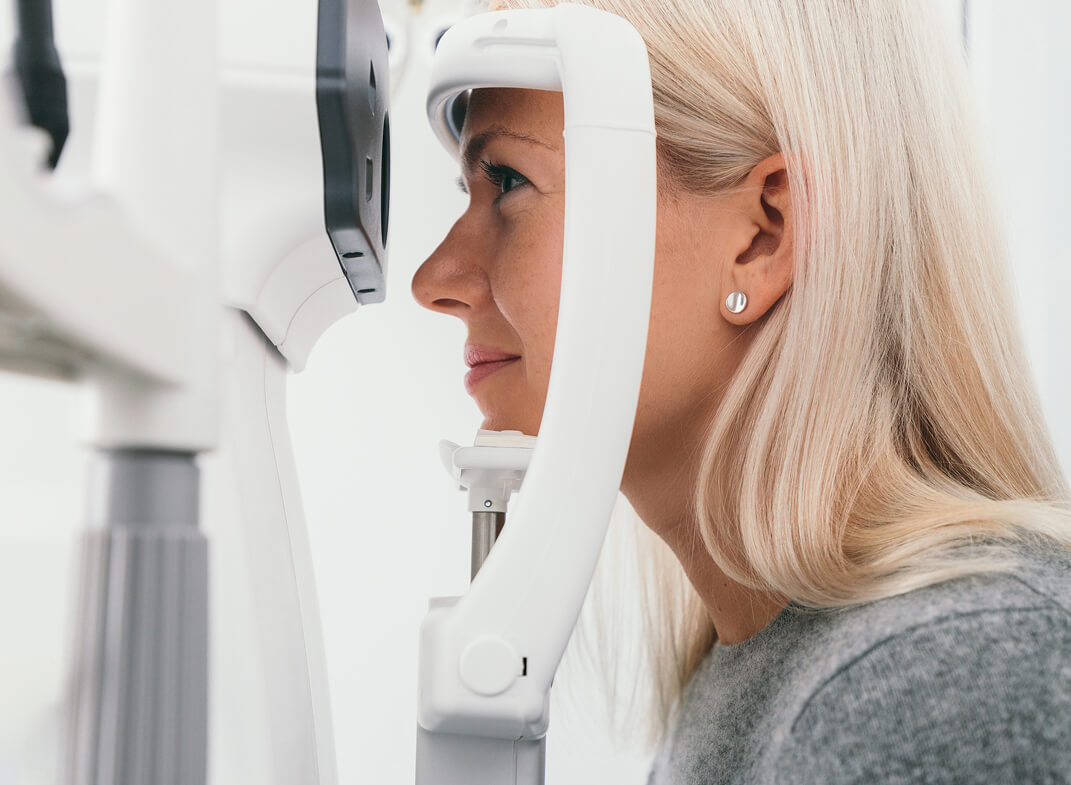 Frau blickt in Augenuntersuchungsgerät.