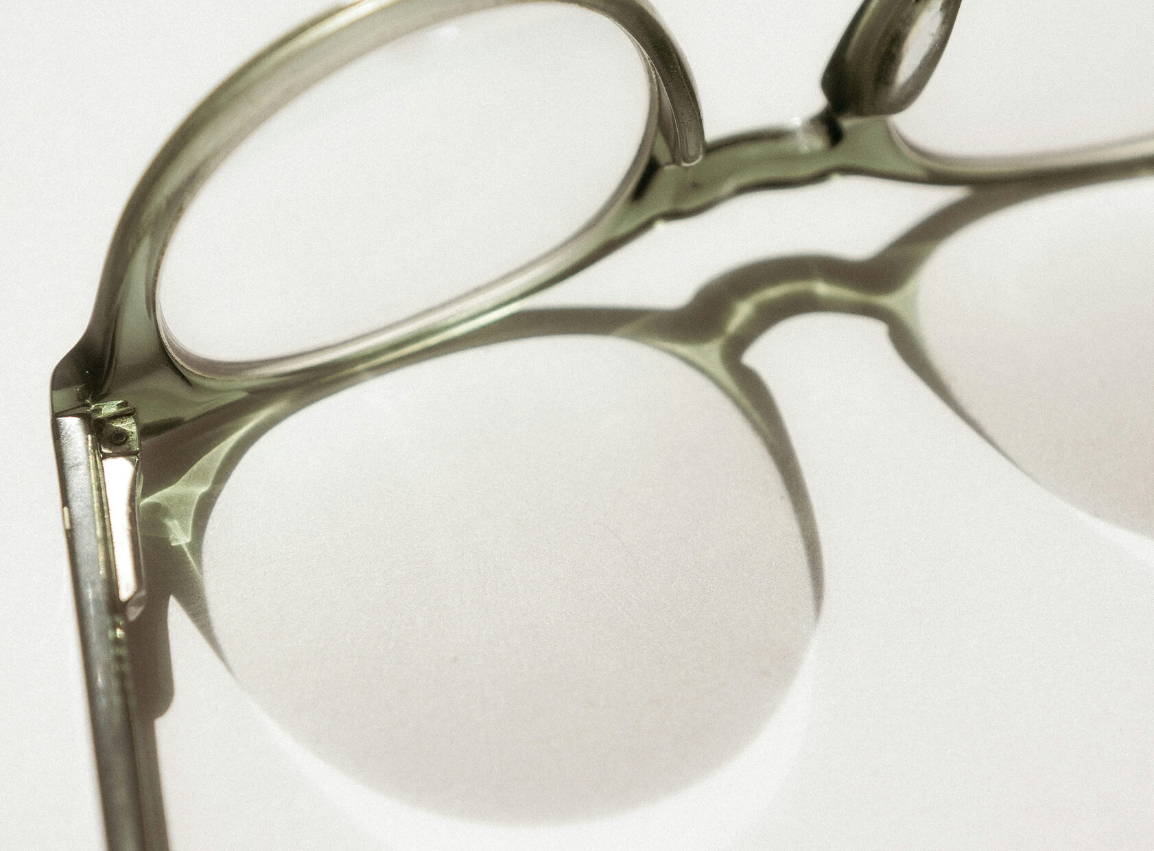 Transparente grüne Brille mit Schattenwurf.