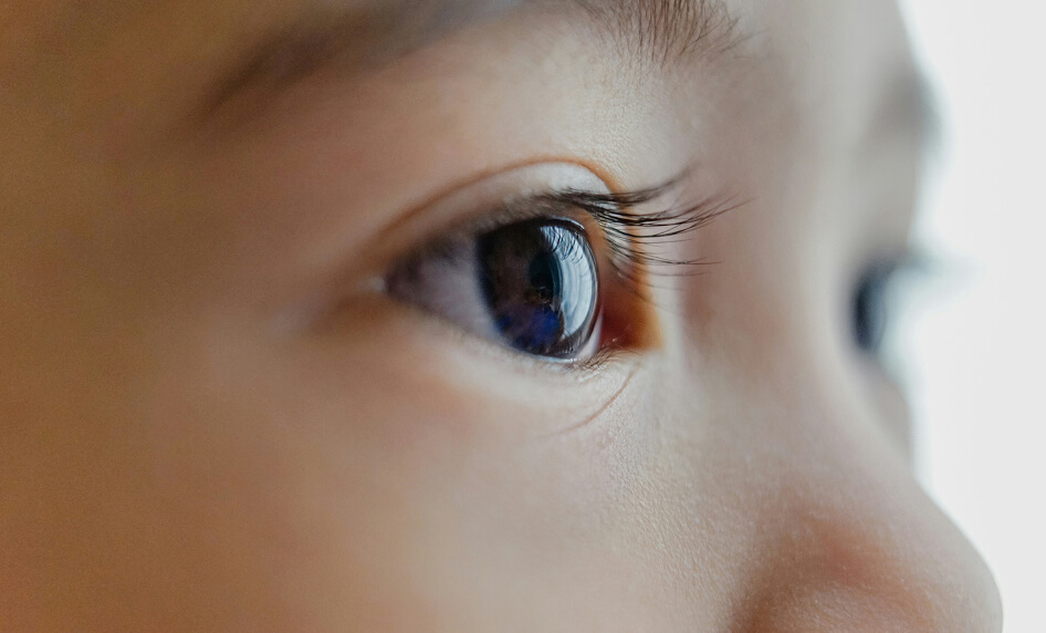 Auge im Seitenprofil mit Wimpern und Reflexion.