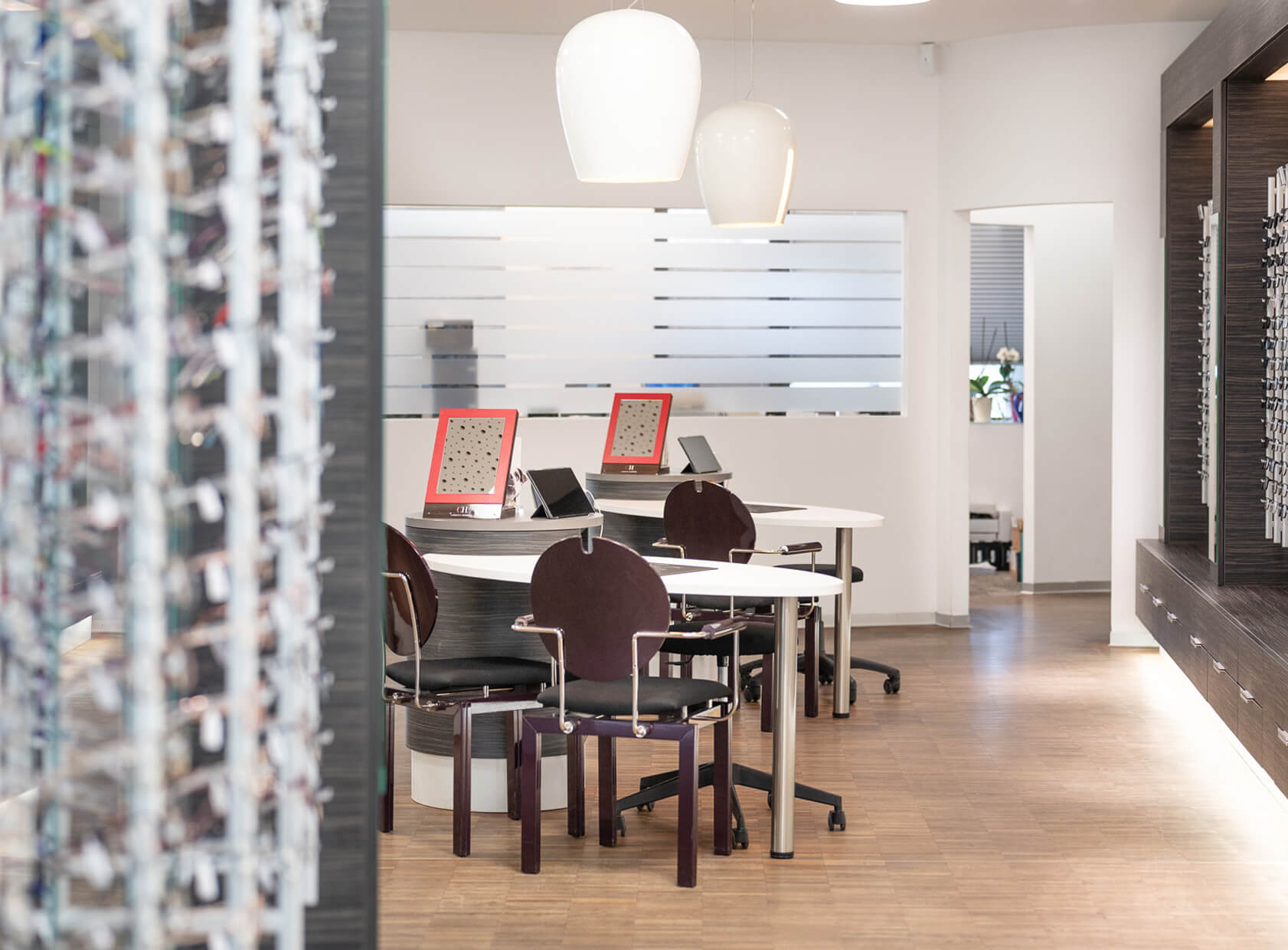 Optikerladen mit Beratungsplätzen und Brillenregalen.